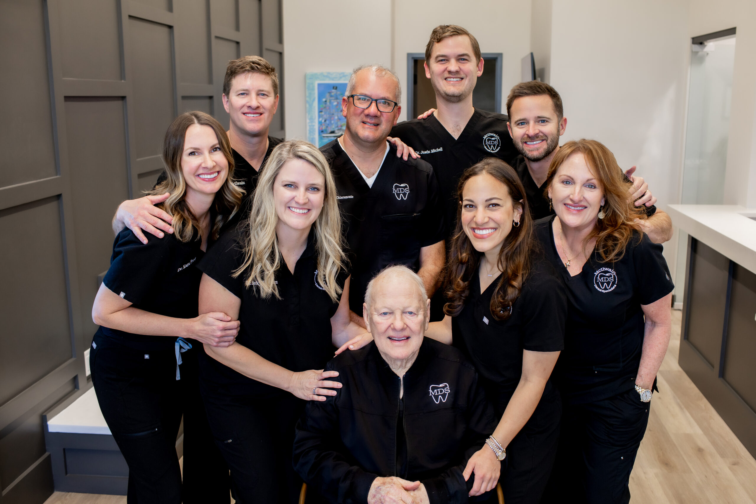 Group of dentists in black scrubs in a dental clinic