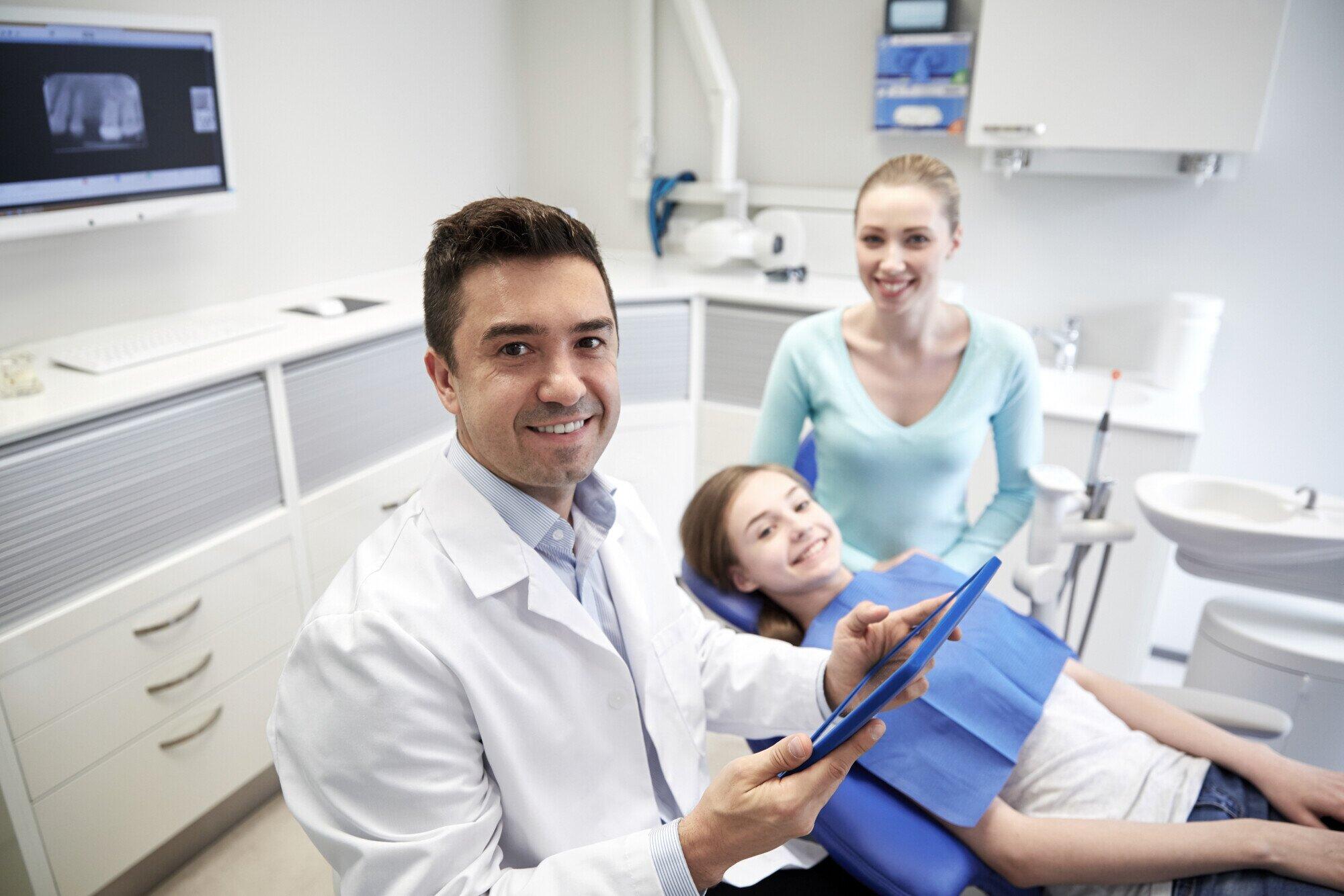 Dentist smiling with a young patient in a dental office