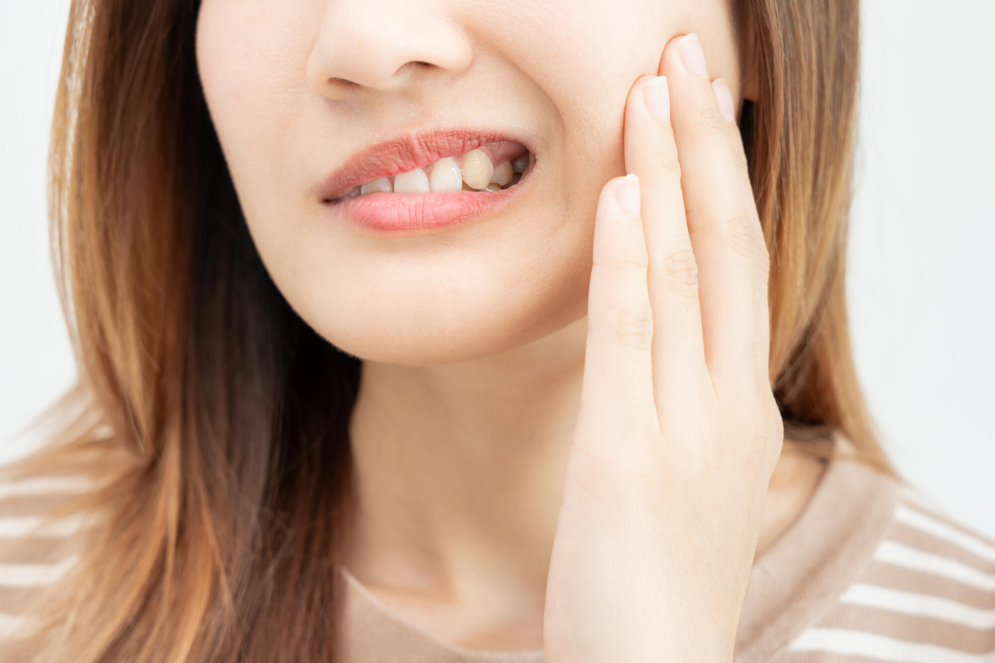 Women holding jaw in pain from clinching